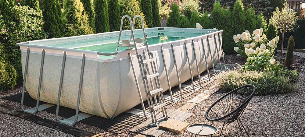 Long, above ground, rectangular, rack swimming pool outdoor in the pebble garden nook