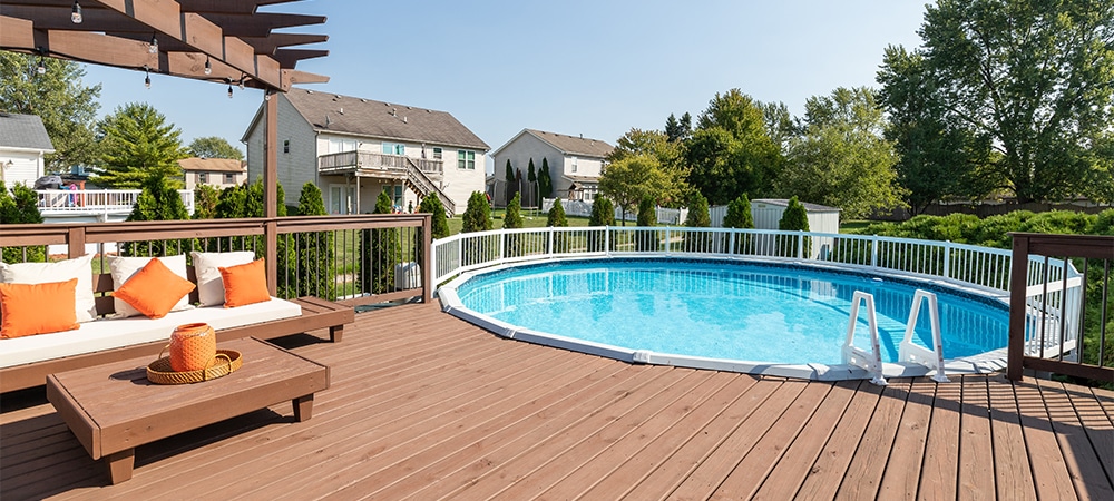 above ground swimming pool with deck, fence and ladder