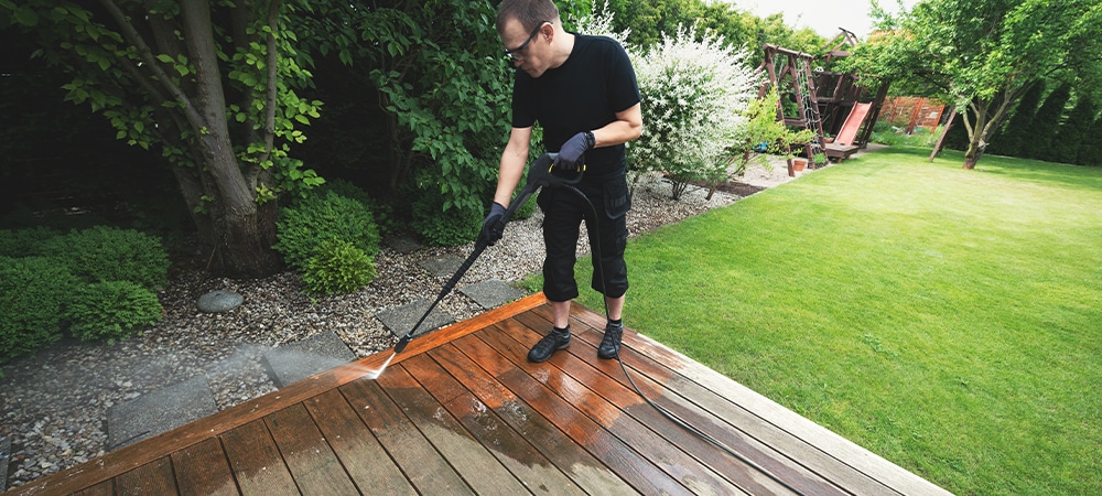 man cleaning the trex decking